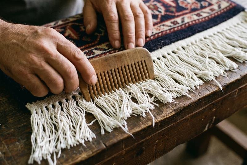 Franges de tapis peignées à la main, moitié refaites, moitié effilochées
