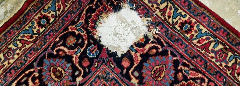 Lacune sur un tapis persan sombre, chaîne et trame apparentes